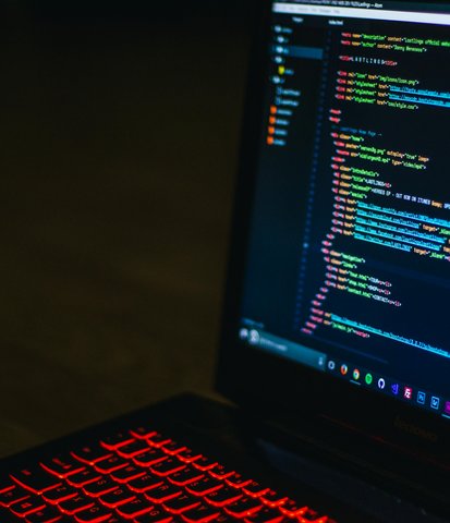 Visual Studio Code open with code displaying on a laptop with an RGB keyboard